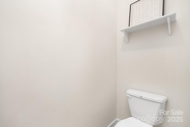 bathroom with baseboards and toilet