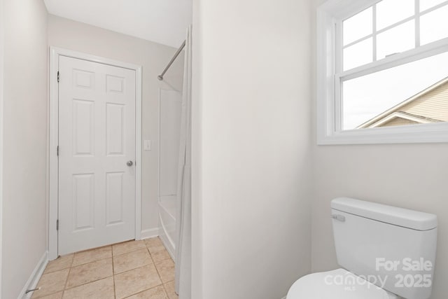 bathroom with toilet, bathing tub / shower combination, tile patterned floors, and baseboards