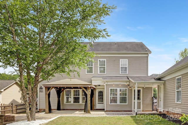 back of property featuring a yard, fence, a gazebo, and a patio area