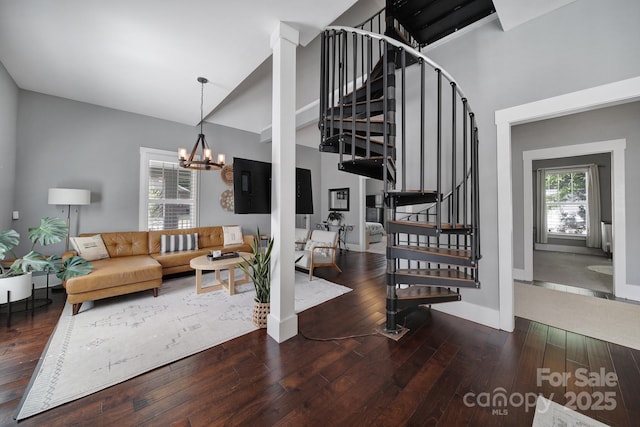 interior space with baseboards, high vaulted ceiling, hardwood / wood-style flooring, and a notable chandelier