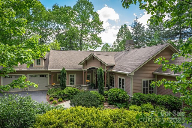 168 Chattooga Run, Hendersonville, NC 28739 - single story home featuring asphalt driveway, a chimney, a shingled roof, and a garage