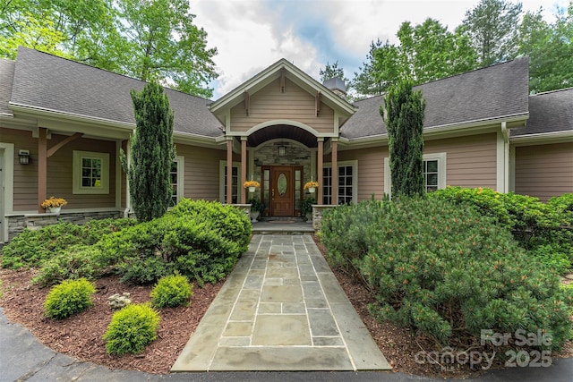 168 Chattooga Run, Hendersonville, NC 28739 - view of exterior entry featuring stone siding and a shingled roof