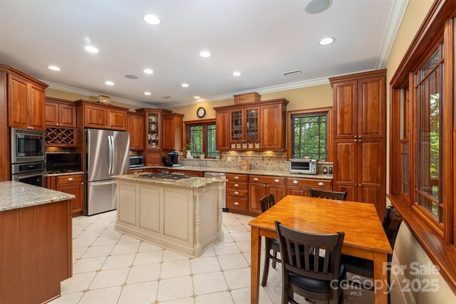 168 Chattooga Run, Hendersonville, NC 28739 - kitchen with stainless steel appliances, plenty of natural light, crown molding, decorative backsplash, and glass insert cabinets