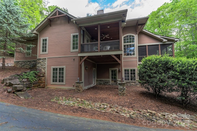 168 Chattooga Run, Hendersonville, NC 28739 - back of house with a sunroom, a ceiling fan, a chimney, and stone siding