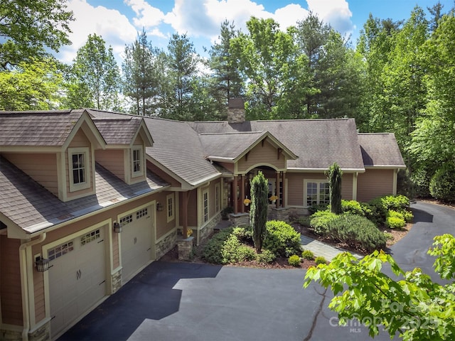 168 Chattooga Run, Hendersonville, NC 28739 - view of front of home with driveway, a chimney, an attached garage, and stone siding