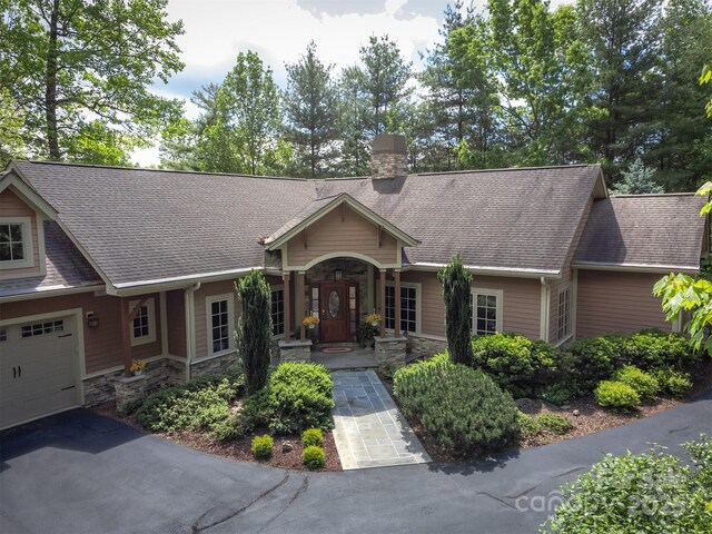 168 Chattooga Run, Hendersonville, NC 28739 - single story home with stone siding, a chimney, a shingled roof, and an attached garage
