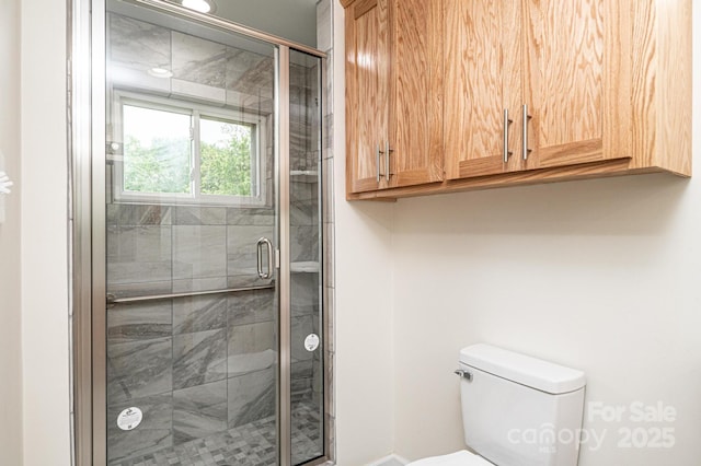full bath with toilet, baseboards, and a shower stall