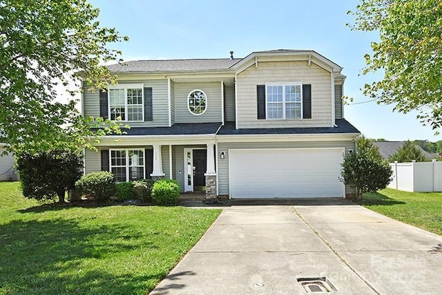 traditional-style house featuring concrete driveway, a front lawn, fence, and a garage