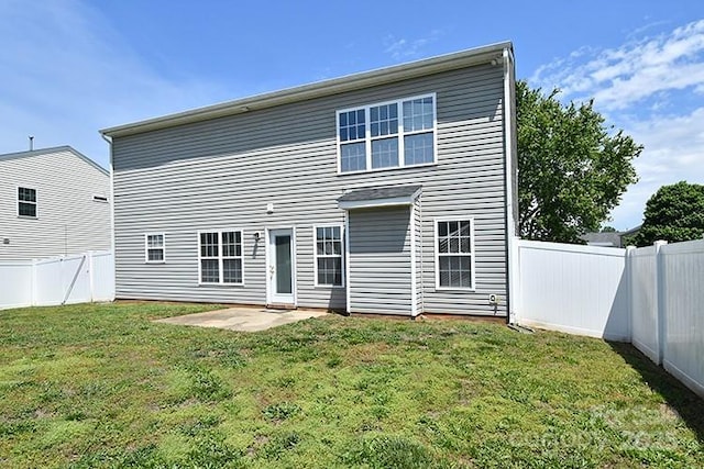 rear view of house featuring a patio area, a fenced backyard, and a yard