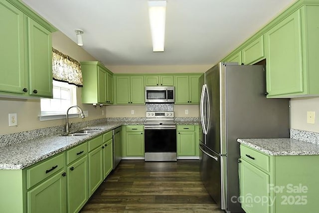 kitchen featuring dark wood-style flooring, green cabinetry, stainless steel appliances, and a sink