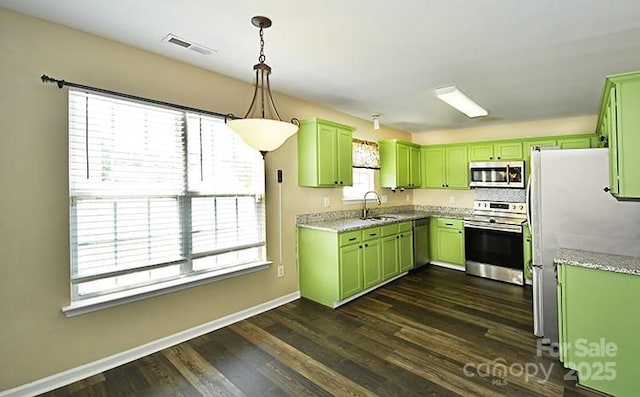 kitchen with visible vents, green cabinetry, stainless steel appliances, and a sink