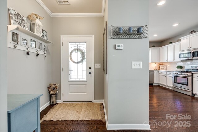 doorway with visible vents, baseboards, ornamental molding, recessed lighting, and dark wood-type flooring