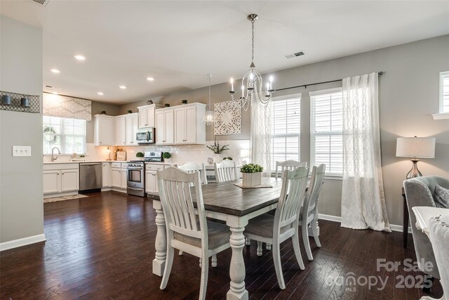dining room with dark wood-style flooring, baseboards, a notable chandelier, and recessed lighting