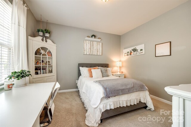 bedroom featuring baseboards and light carpet