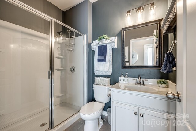 bathroom with vanity, tile patterned flooring, a shower stall, and toilet