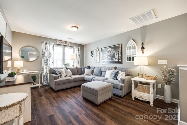 living area featuring visible vents and dark wood-type flooring