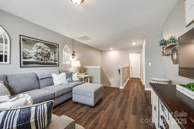 living room with dark wood-style flooring, baseboards, visible vents, and recessed lighting