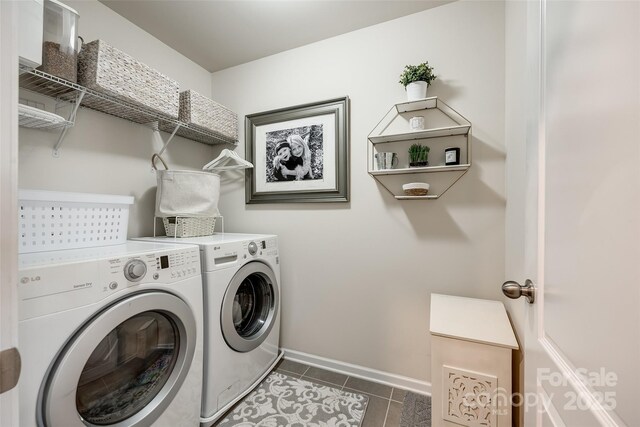 clothes washing area featuring separate washer and dryer, laundry area, baseboards, and tile patterned flooring