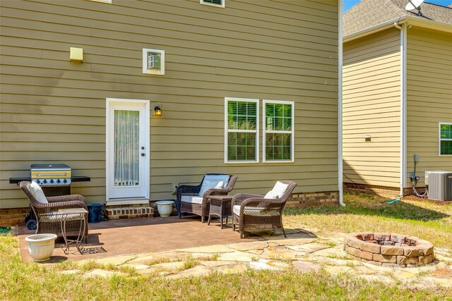 view of patio with central air condition unit and an outdoor fire pit