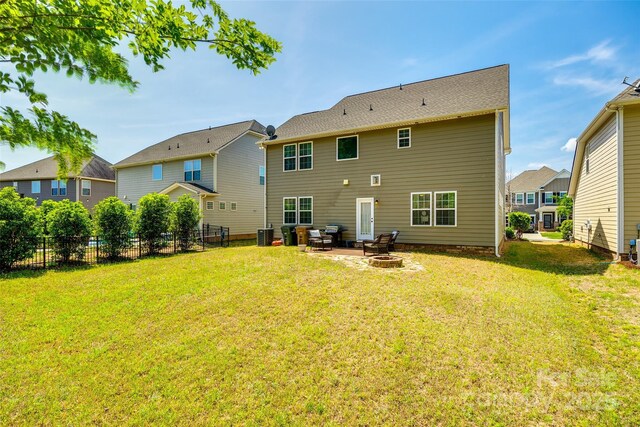 rear view of house featuring a patio, an outdoor fire pit, fence, and a yard