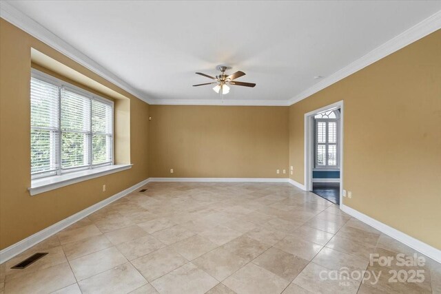 spare room with a ceiling fan, ornamental molding, light tile patterned flooring, and baseboards