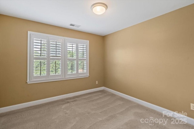 unfurnished room with baseboards and light colored carpet