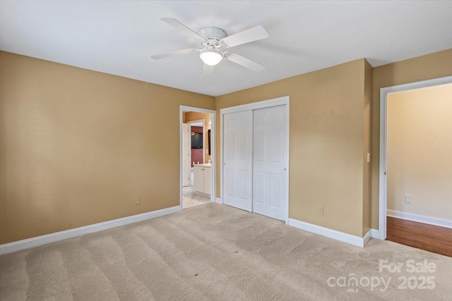 unfurnished bedroom with carpet flooring, a closet, baseboards, and ceiling fan