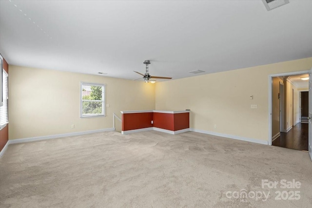 unfurnished living room with carpet flooring, baseboards, and ceiling fan