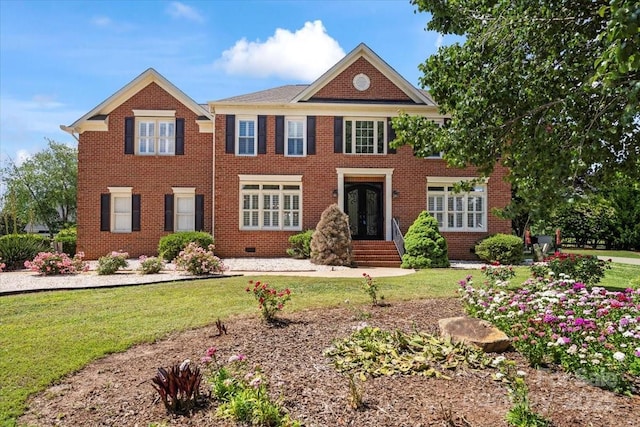 view of front of home with french doors, a front yard, and brick siding