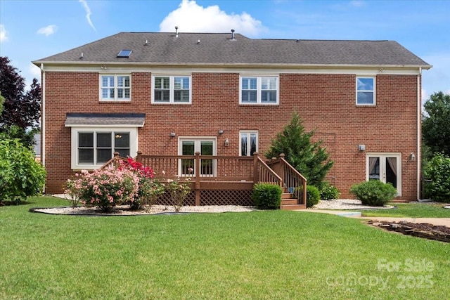 back of property with a deck, a yard, and brick siding