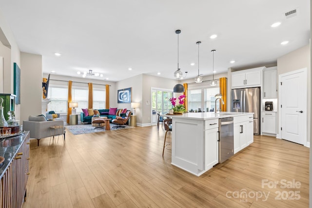12705 Twilight Dr, Mint Hill, NC 28227 - kitchen with open floor plan, appliances with stainless steel finishes, visible vents, and light wood-style floors