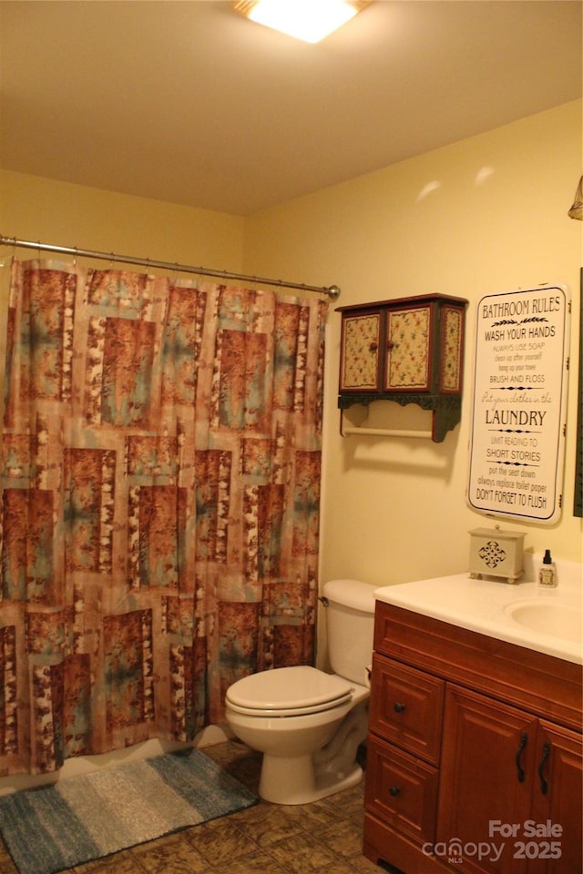 full bathroom featuring a shower with curtain, vanity, and toilet