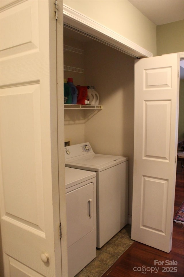 washroom featuring washing machine and dryer, dark wood-type flooring, and laundry area