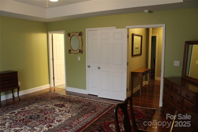 bedroom featuring baseboards and dark wood-style flooring