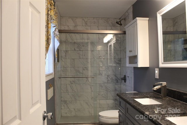bathroom featuring a shower stall, toilet, and vanity