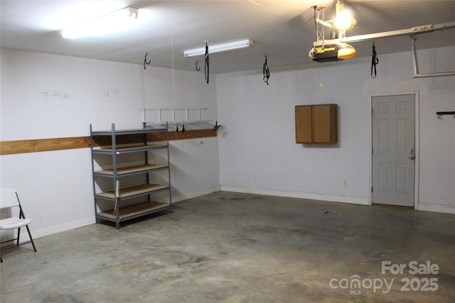 garage with baseboards and a garage door opener