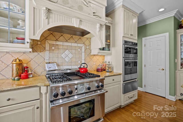 6914 Riesman Ln Unit 95, Charlotte, NC 28210 - kitchen featuring ornamental molding, a warming drawer, light wood-type flooring, glass insert cabinets, and appliances with stainless steel finishes