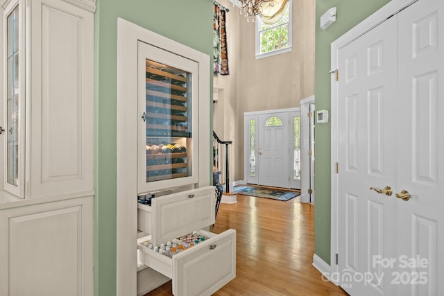 6914 Riesman Ln Unit 95, Charlotte, NC 28210 - entryway featuring baseboards, an inviting chandelier, a towering ceiling, and light wood-type flooring
