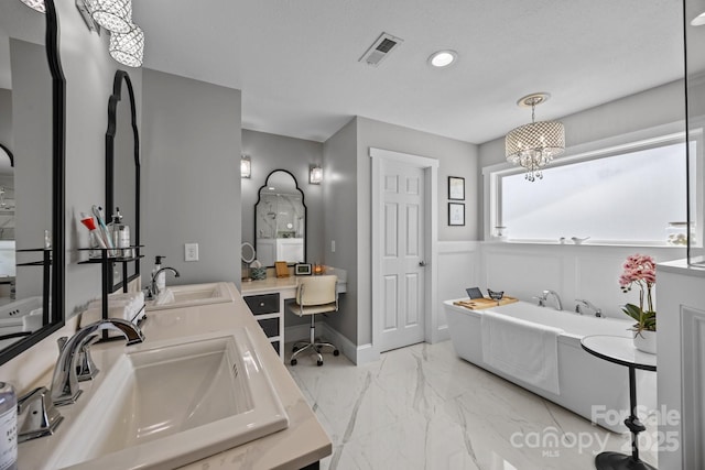 bathroom featuring visible vents, a tub to relax in, marble finish floor, and a sink