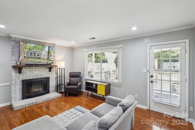 6412 Old Meadow Rd, Charlotte, NC 28227 - living room with wood finished floors, ornamental molding, healthy amount of natural light, a brick fireplace, and recessed lighting