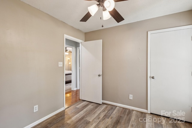6412 Old Meadow Rd, Charlotte, NC 28227 - unfurnished bedroom featuring wood finished floors, baseboards, and ceiling fan