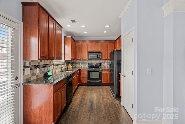 1948 Winpole Ln, Charlotte, NC 28273 - kitchen featuring dark stone countertops, a sink, visible vents, black appliances, and dark wood finished floors
