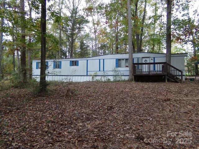 back of property featuring stairway and a wooden deck