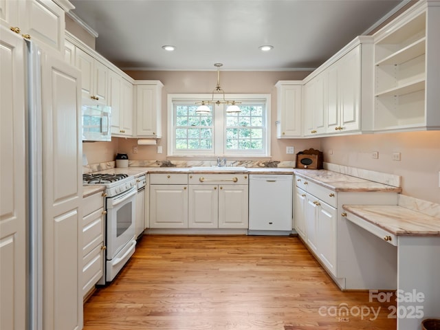 10 Stuyvesant Rd, Asheville, NC 28803 - kitchen with hanging light fixtures, a sink, light wood-style floors, white appliances, and white cabinetry