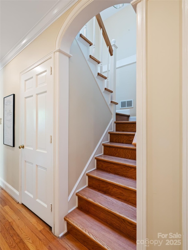 10 Stuyvesant Rd, Asheville, NC 28803 - stairway with arched walkways, baseboards, visible vents, wood finished floors, and crown molding