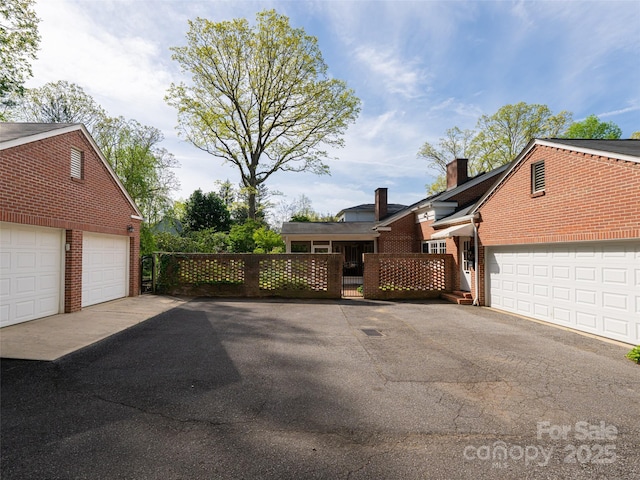 10 Stuyvesant Rd, Asheville, NC 28803 - view of front of house with brick siding, a chimney, a garage, and fence