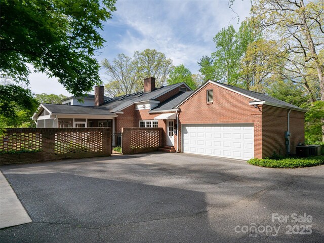 10 Stuyvesant Rd, Asheville, NC 28803 - view of front of property with a chimney, driveway, fence, a garage, and brick siding