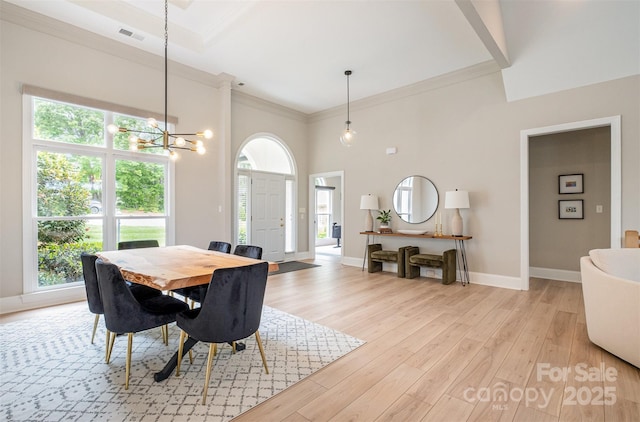 dining room with crown molding, light wood-type flooring, a healthy amount of sunlight, and an inviting chandelier