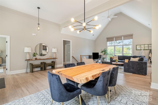 dining space with an inviting chandelier, high vaulted ceiling, baseboards, and light wood-type flooring
