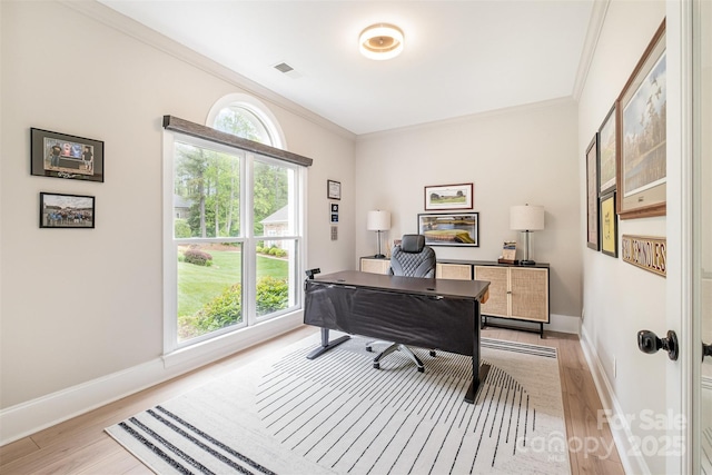 office featuring visible vents, ornamental molding, light wood finished floors, and baseboards